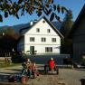 Ziegelau farm, © zVg Children playing on a farm with Kettcars and a goat in the foreground.
