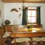 Common room, © zVg Cozy lounge with wooden furniture, table, corner bench and decorations on the wall.