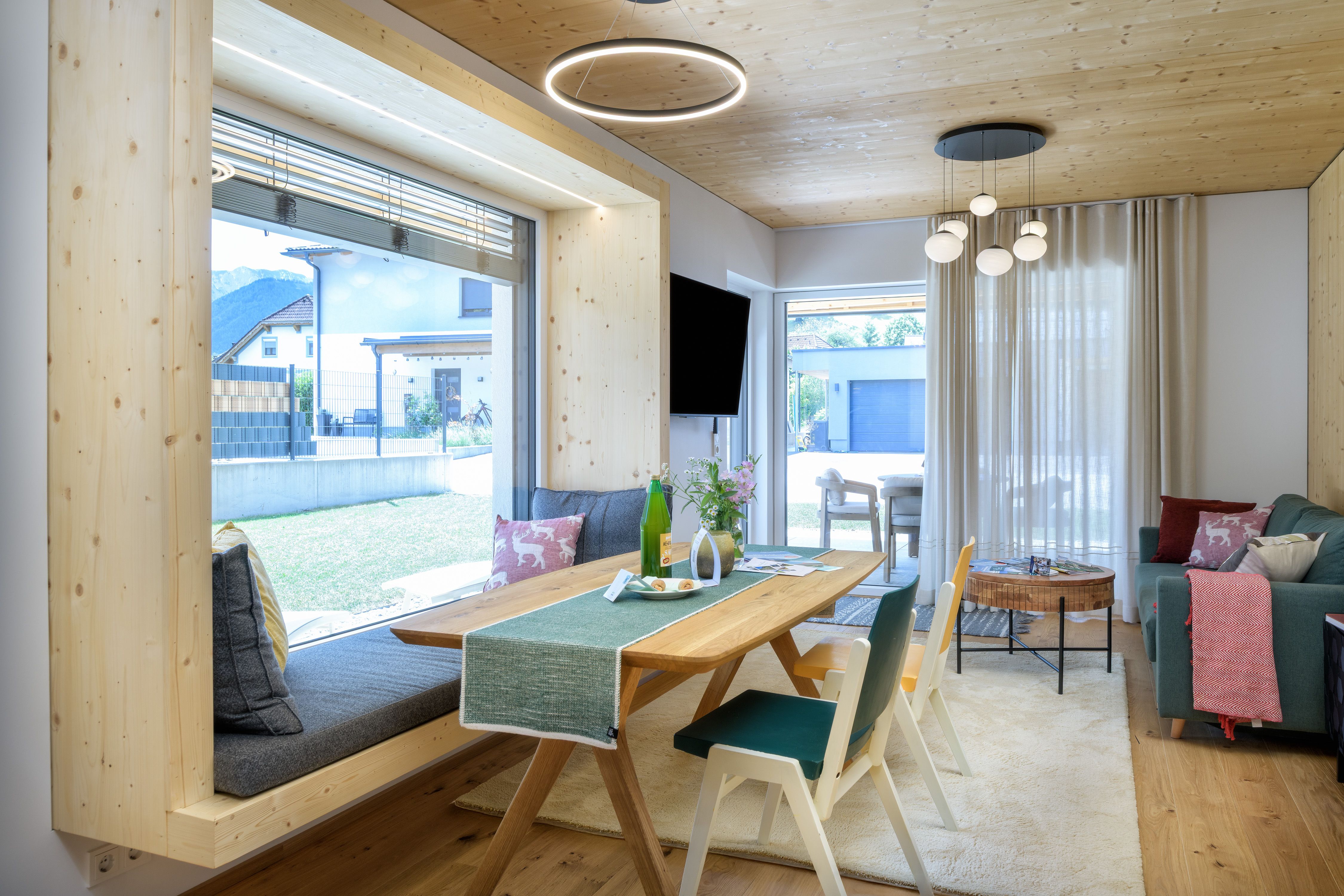 A modern living room with wooden accents, a large window, and stylish furnishings.