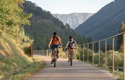 Zwei Radfahrer gleiten entspannt entlang des Ybbstalradwegs, umgeben von der majestätischen Kulisse der Ybbstaler Alpen. Die sanften Hügel und das klare, blaue Himmel schaffen eine einladende Atmosphäre für Abenteuerlustige und Naturliebhaber. Hier wird der Sommer in den Bergen zum unvergesslichen Erlebnis.