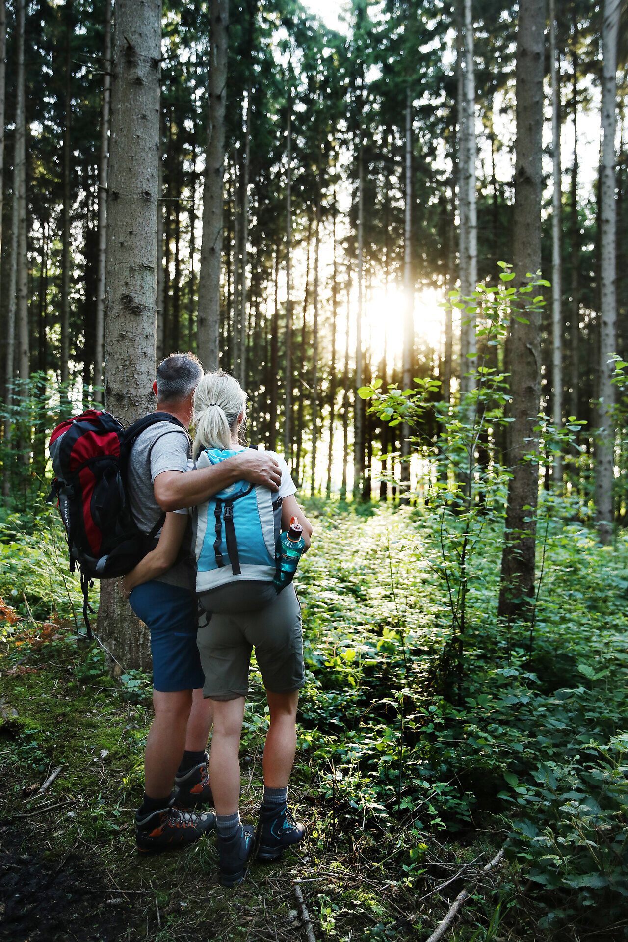 Pilgerpaar mit Rucksack im Wald entlang der Via Trinitatis.