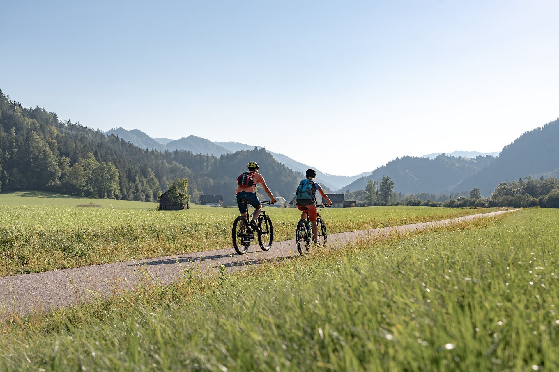Zwei Radfahrer genießen die frische Bergluft und die atemberaubende Landschaft der Ybbstaler Alpen. Umgeben von saftigem Grün und majestätischen Bergen, erleben sie die Freiheit und den Spaß am Radfahren in dieser idyllischen Umgebung.