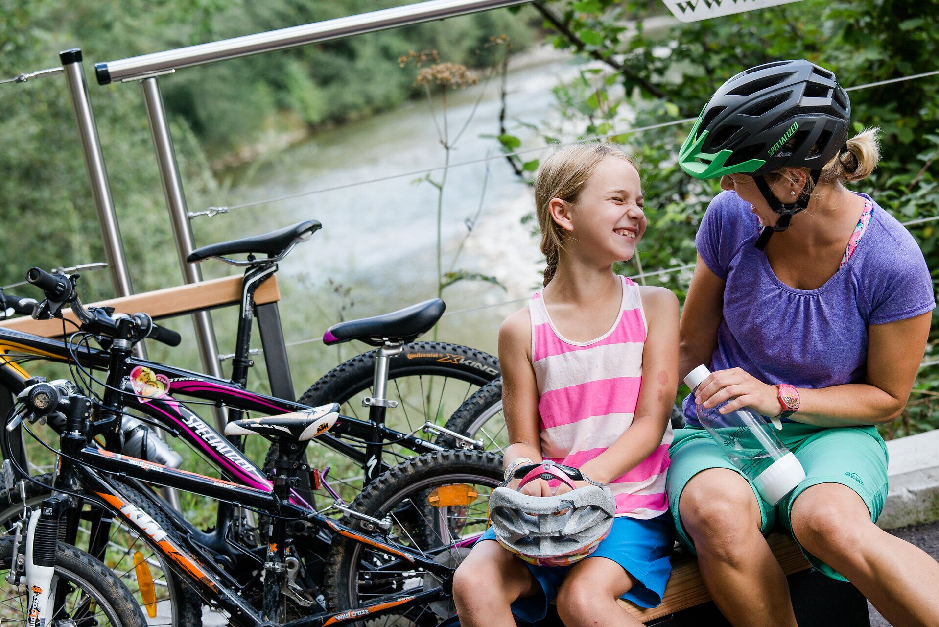 Ein fröhliches Lächeln verbindet Mutter und Tochter, während sie eine wohlverdiente Pause nach einer Radtour genießen. Umgeben von der malerischen Natur des Mostviertels, strahlt die Szene eine herzliche und entspannte Atmosphäre aus, die zum Verweilen einlädt.