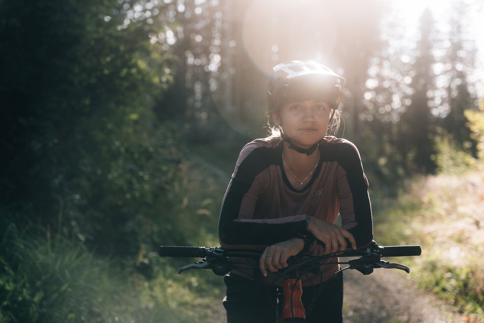 In der warmen Abendsonne lehnt sich eine Mountainbikerin entspannt an ihr Rad, während die sanften Hügel des Mostviertels im Hintergrund leuchten. Die frische Luft und die umgebende Natur laden dazu ein, die Freiheit und das Abenteuer des Radfahrens zu genießen. Hier, wo die Wege durch dichte Wälder führen, wird jeder Moment zu einem unvergesslichen Erlebnis.