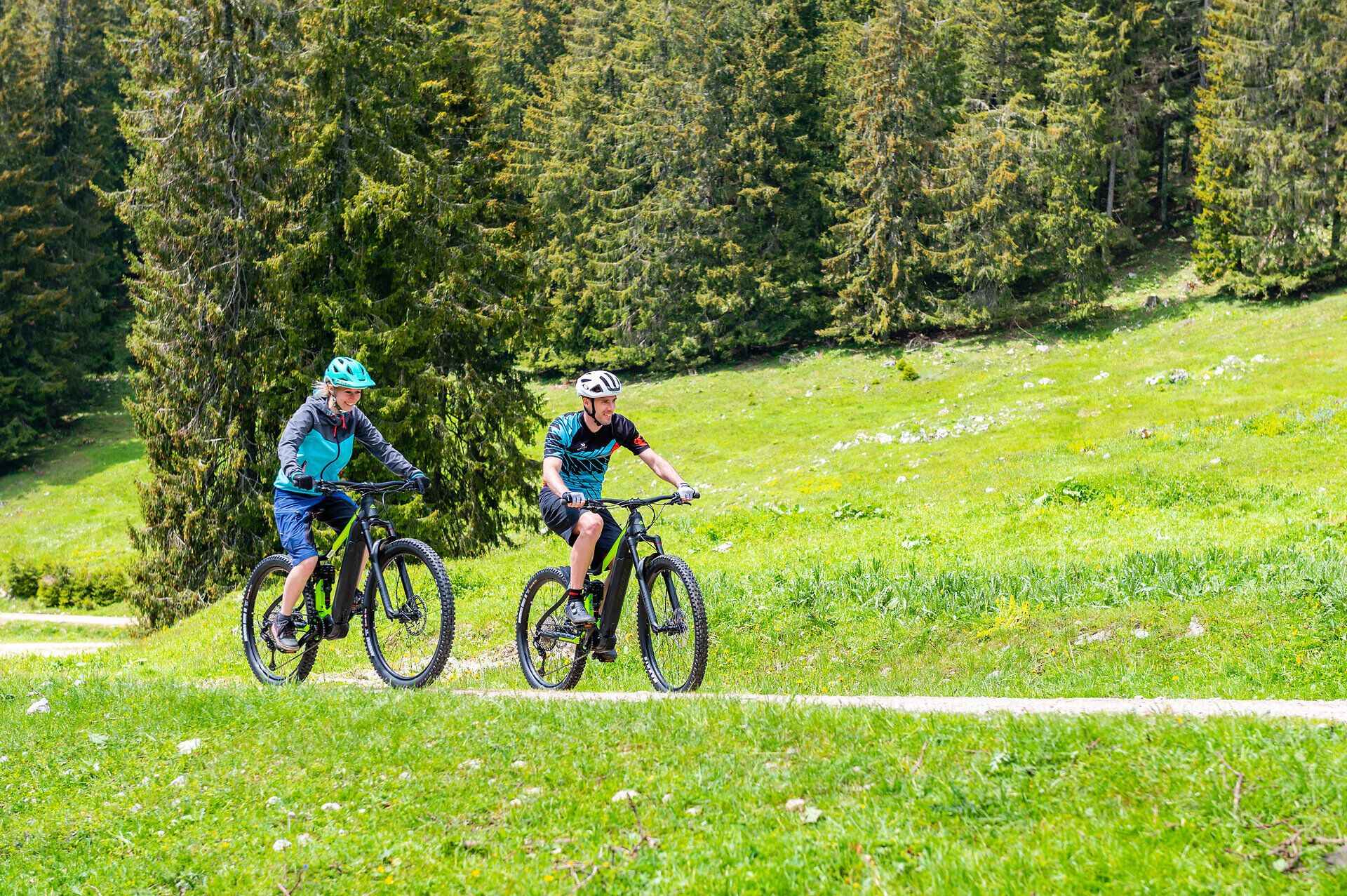 Zwei Mountainbiker genießen die frische Bergluft und die atemberaubende Landschaft der Ybbstaler Alpen. Umgeben von saftigem Grün und majestätischen Nadelbäumen, erleben sie ein unvergessliches Abenteuer auf den malerischen Trails.