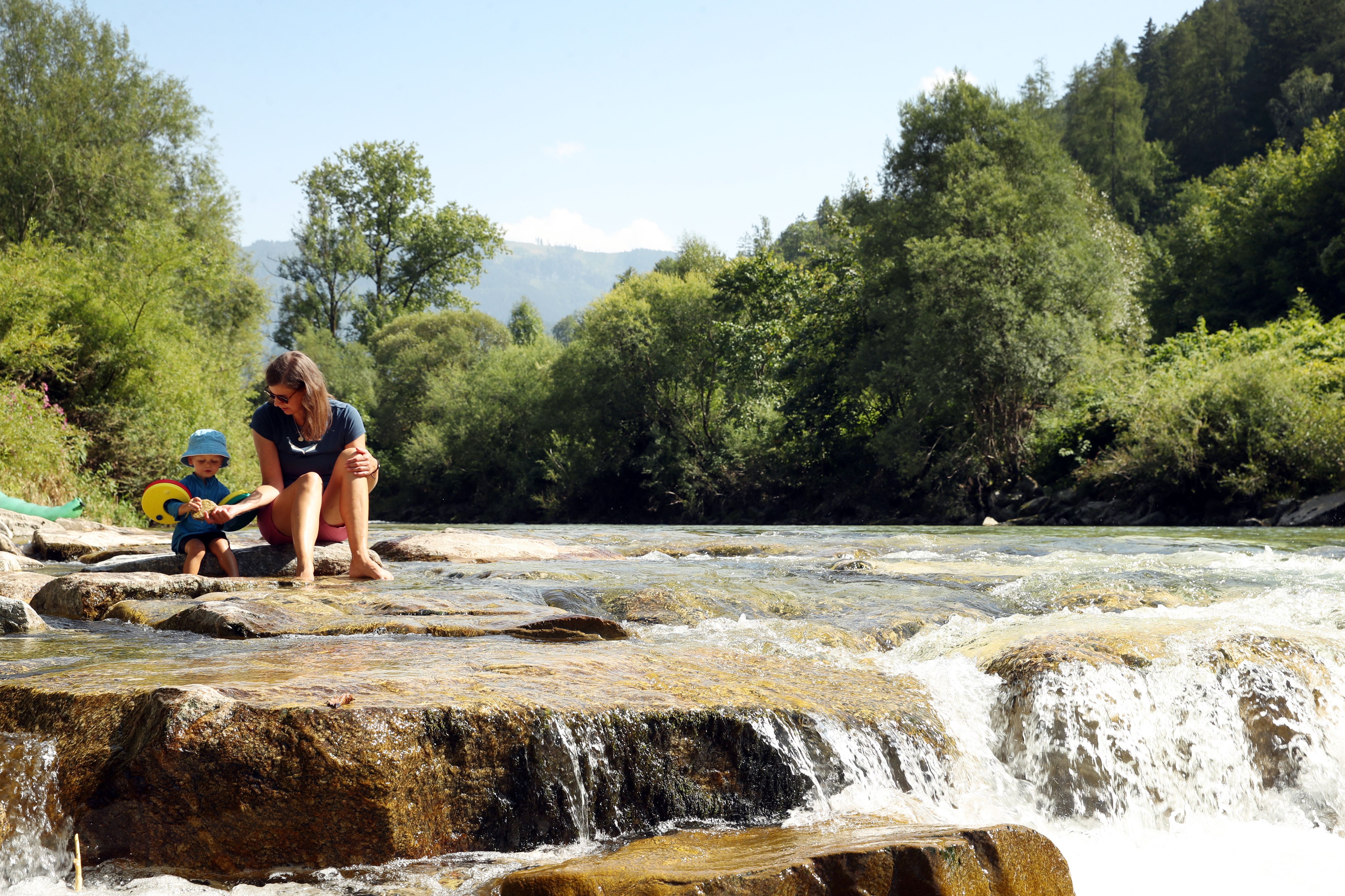 Mama mit Kind am Wasserrand entlang der Ybbs