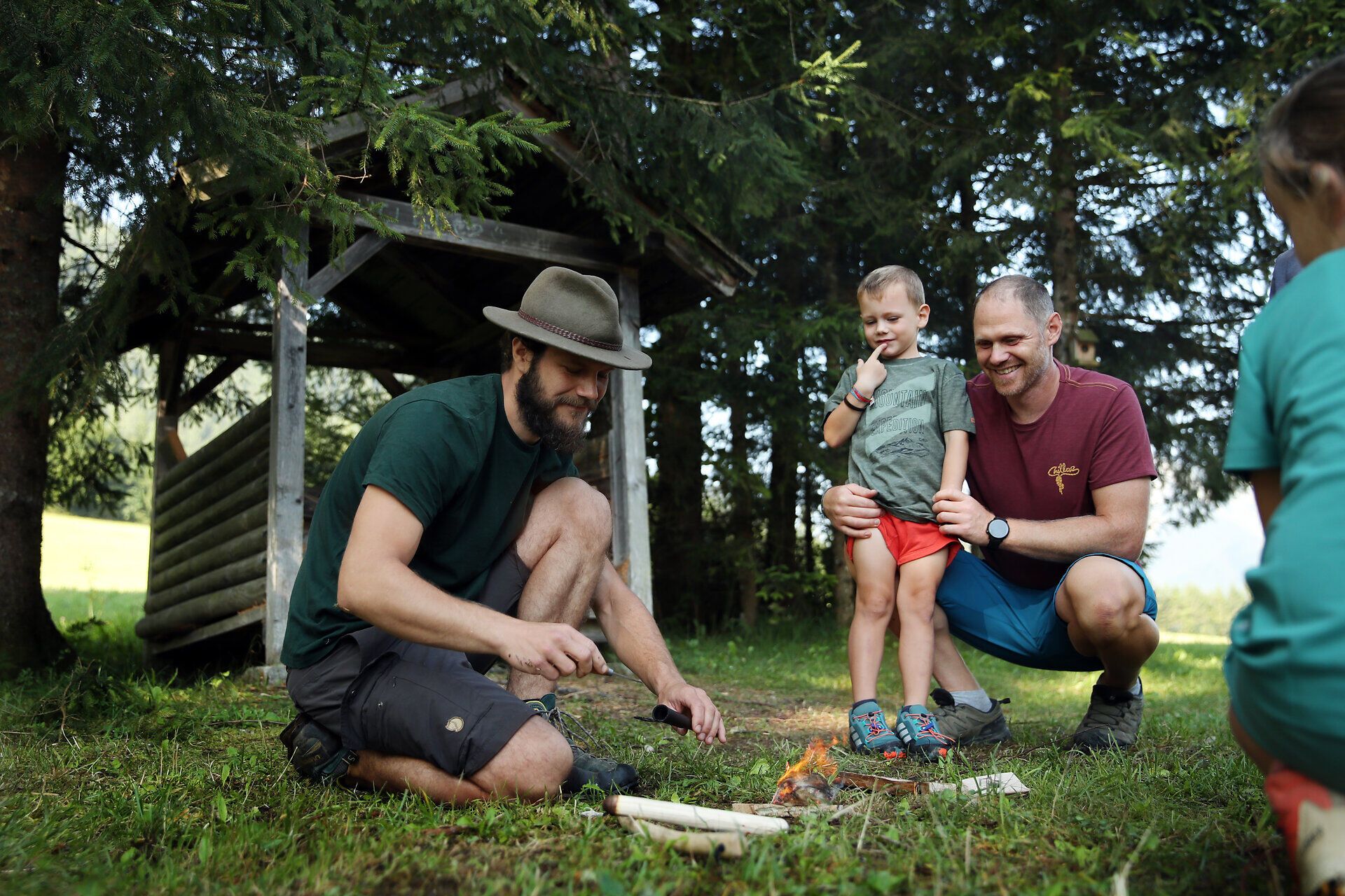 Ein Naturvermittler packt gerade sein Messer wieder ein. Er zeigt, dass ein Baumschwamm als Anzünder verwendet werden kann.