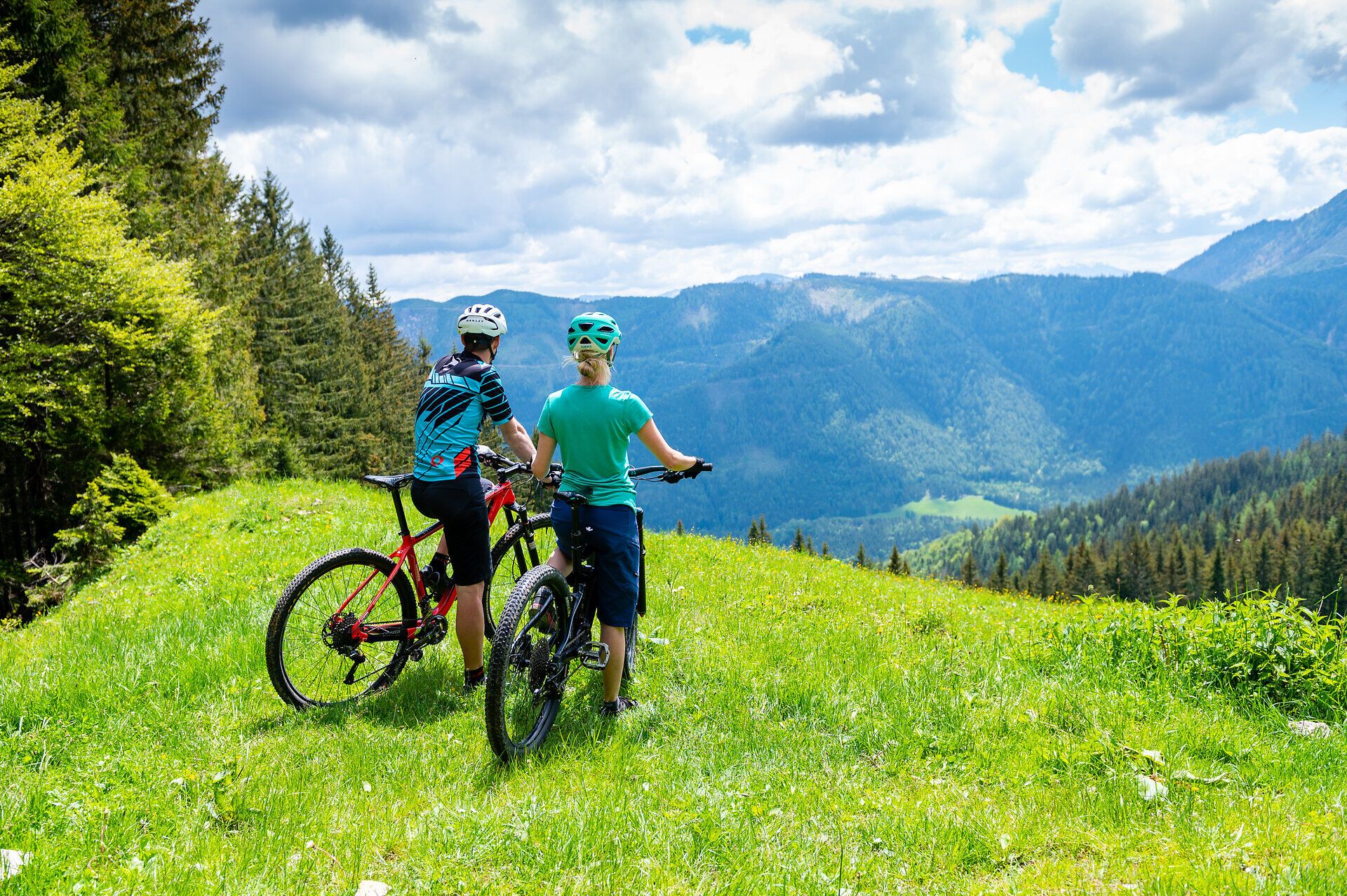 Inmitten der majestätischen Ybbstaler Alpen genießen zwei Mountainbiker die atemberaubende Aussicht auf die sanften Hügel und das üppige Grün der Almen. Die frische Bergluft und die beeindruckenden Landschaften laden zu unvergesslichen Abenteuern ein.