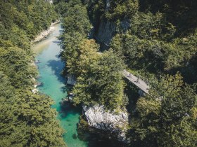 Aerial view of the Ybbs, surrounded by wooded vegetation and next to it two cyclists on the Ybbstal cycle path